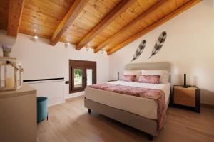 una camera con un grande letto e soffitti in legno di Villa Elena Corfu in Doukades a Doukádes