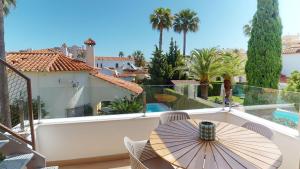 a patio with a table and an umbrella on a balcony at Sunrise by ON Travel in Oliva