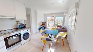 a kitchen and living room with a table and chairs at Sunrise by ON Travel in Oliva