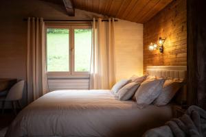 a bedroom with a large bed with a window at Venez chez vous - Chalet le Dahu in Rovagny