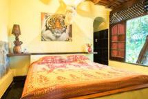 1 dormitorio con 1 cama y una pintura en la pared en Pousada Villa Amari, en Armação do Tairu