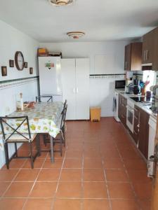 a kitchen with a table and a refrigerator at Casa rural los Miradores in Muros de Nalón