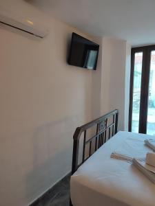a bedroom with a bed with a tv on the wall at Porto Kagio Villa beach in Akhíllion