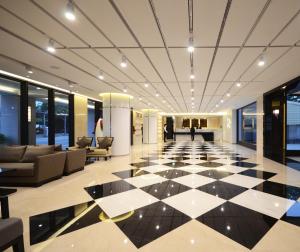 un vestíbulo con suelo a cuadros en blanco y negro en Shiny Ocean Hotel en Hualien