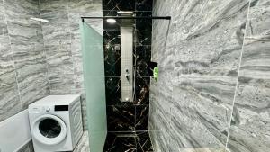 une salle de bain avec une machine à laver à côté d'un mur en pierre dans l'établissement BB Apartment Pristina Kosovo, à Pristina 3 autres photos