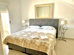 een slaapkamer met een bed met 2 boeken en een spiegel bij Dúplex Jardines de Denia I in Denia