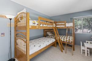 two bunk beds in a room with a table at Luxe Mountain Retreat Lake Village Close Game Room AC Backs up to trails in Lake Arrowhead