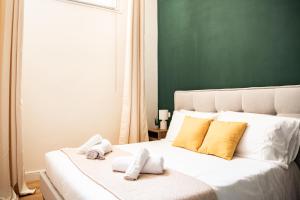 een slaapkamer met een wit bed met handdoeken erop bij Domina Apartments Roma - San Pietro 2 in Rome