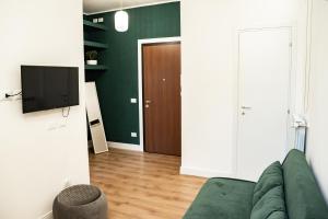 een woonkamer met een groene bank en een televisie bij Domina Apartments Roma - San Pietro 2 in Rome