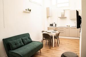 een woonkamer met een groene bank en een tafel bij Domina Apartments Roma - San Pietro 2 in Rome