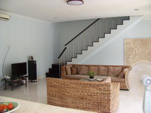 a living room with a couch and a staircase at Vista del Mar in Candidasa