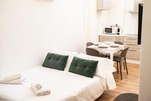 een witte kamer met een bed en een tafel met stoelen bij Domina Apartments Roma - San Pietro 2 in Rome