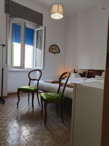 a room with two chairs and a bed with a window at B&B Mavipagi in Verona