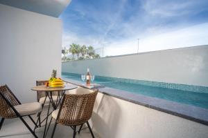 a balcony with a table and chairs and a swimming pool at Luminous luxury living in Kallithea Halkidikis