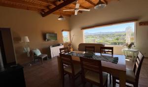 a dining room with a table and chairs and a living room at Lugar de PAZ en las Sierras in Sierra de la Ventana