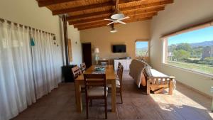 a living room with a dining room table and a window at Lugar de PAZ en las Sierras in Sierra de la Ventana