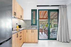 a kitchen with wooden cabinets and a sliding glass door at George Studios in Yenion