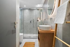 a bathroom with a shower and a sink and a toilet at George Studios in Yenion