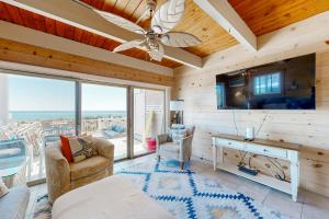 a living room with a ceiling fan and a tv at Caravelle 1 in Ocean City