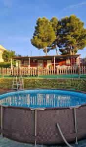a swimming pool with a house in the background at Casita con piscina cerca de Chinchón, Aranjuez y Parque Warner in Colmenar de Oreja