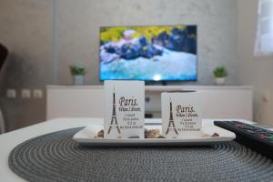 Dos velas en un plato sobre una mesa con un control remoto. en Golden Royal M, en Kragujevac