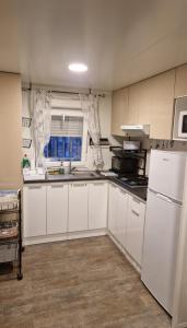 a kitchen with white cabinets and a sink and a window at Casita con piscina cerca de Chinchón, Aranjuez y Parque Warner in Colmenar de Oreja +14 photos