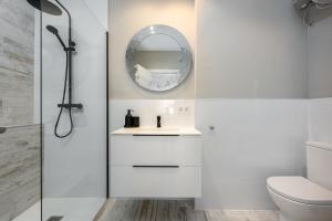 Un baño blanco con lavabo y espejo. en Torreguadiaro flat - 2 min to beach, en San Roque