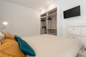 Un dormitorio con una cama y un televisor de pantalla plana. en Torreguadiaro flat - 2 min to beach, en San Roque