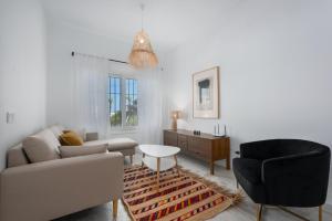 una sala de estar con un sofá y una silla en Torreguadiaro flat - 2 min to beach, en San Roque