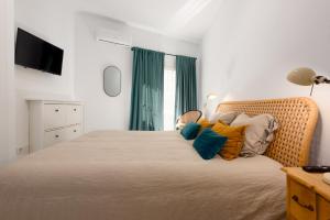 Un dormitorio con una cama grande con almohadas de colores. en Torreguadiaro flat - 2 min to beach, en San Roque