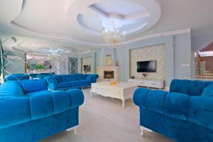 Villa Belis&Liya في فتحية: غرفة معيشة مع أرائك زرقاء وتلفزيون