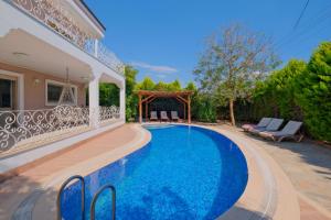 Villa Belis&Liya في فتحية: حمام سباحة في الفناء الخلفي للمنزل