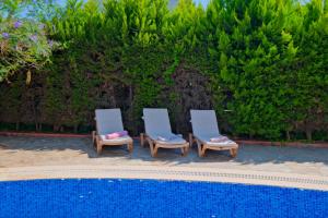 Villa Belis&Liya في فتحية: وجود كرسيين للجلوس بجانب المسبح