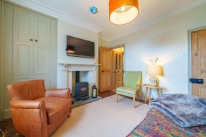 a bedroom with a bed and a chair and a fireplace at Castlehaw View in Sedbergh