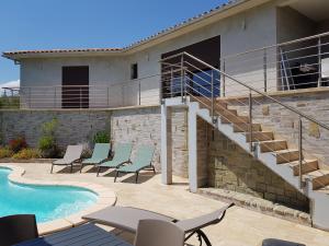 a patio with chairs next to a swimming pool at Villa Mare e Machja in Zonza