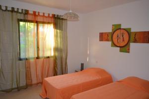 a bedroom with two beds and a clock on the wall at Villa Mare e Machja in Zonza +11 photos