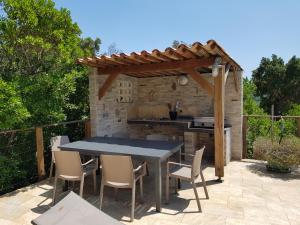 a table and chairs on a patio with a pergola at Villa Mare e Machja in Zonza