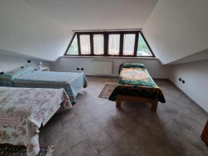 a attic bedroom with two beds and a window at la dimora delle nevi in Ateleta