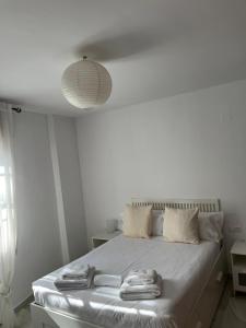 a white bedroom with a bed with towels on it at La Casa del Tambor in Córdoba +15 photos
