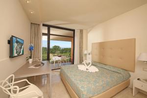 a hotel room with a bed and a desk and a window at Hotel Residence Holiday in Sirmione