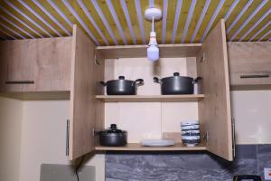 a kitchen with pots and pans on shelves at CK Homes in Voi