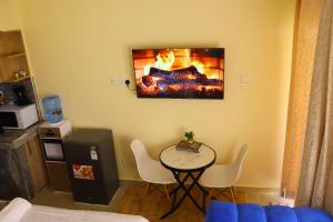 a living room with a table and a fireplace at CK Homes in Voi