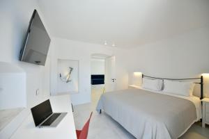 Un dormitorio con una cama y un ordenador portátil sobre una mesa. en Captain Hook, en Hydra