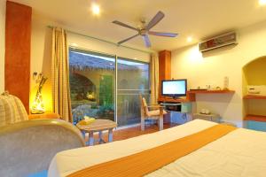 Pandora By Jida Lifestyle Hotel في شاطئ تشاوينغ: غرفة نوم بسرير وتلفزيون ونافذة