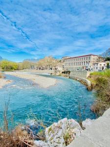 a view of a river with buildings in the background at Gîte de charme au pied du Château de Brissac in Brissac