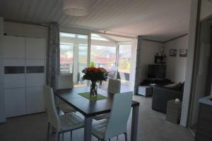 a dining room table with white chairs and a vase of flowers at Chalet in Hudimesnil