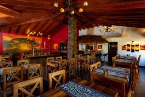 ein Restaurant mit Holztischen und Stühlen und einer Bar in der Unterkunft Mbuni Granja de Avestruz in Nueva Colombia