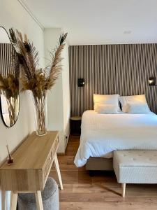 a bedroom with a bed and a table with a vase at Luxe Boshuisje met Privé Wellness & Jacuzzi op de Veluwe in Ermelo