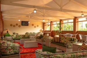 um quarto amplo com sofás, mesas e janelas em Grinbergs Village Hotel em Socorro
