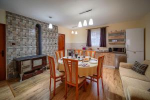 a kitchen and dining room with a table and chairs at Kinga Guesthouse in Şiclod